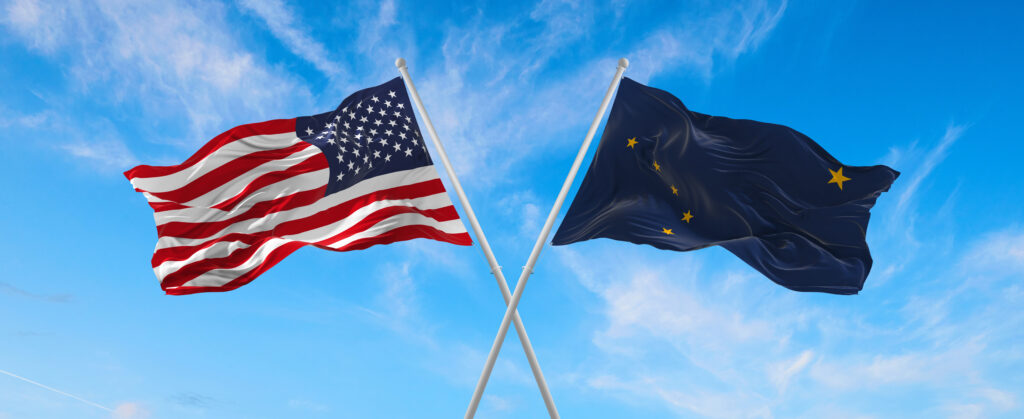 two flags of USA and state of Alaska waving in the wind on flagpoles against sky with clouds on sunny day. 3d illustration