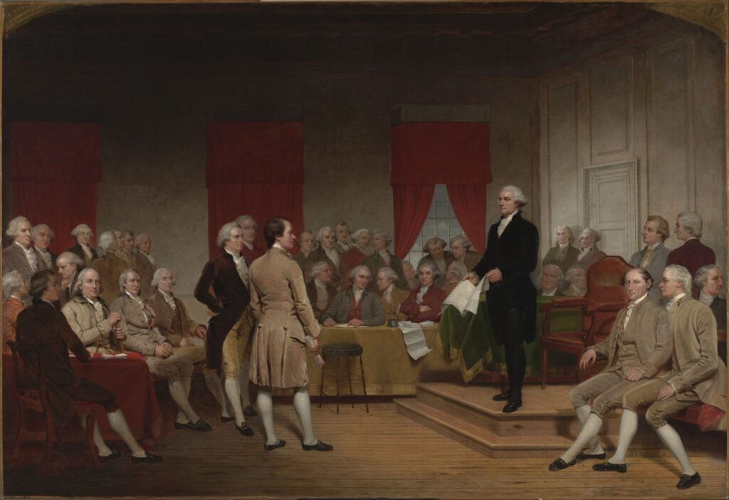 Painting of George Washington standing among delegates during the Constitutional Convention in Philadelphia, surrounded by seated statesmen in eighteenth-century attire.