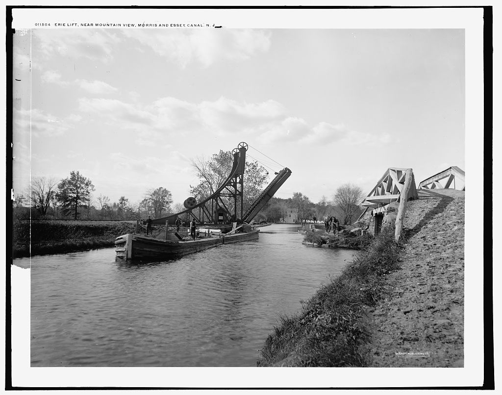 Historic view of commercial traffic along the Erie Canal, with canal boats transporting goods through New York's inland waterway system.
