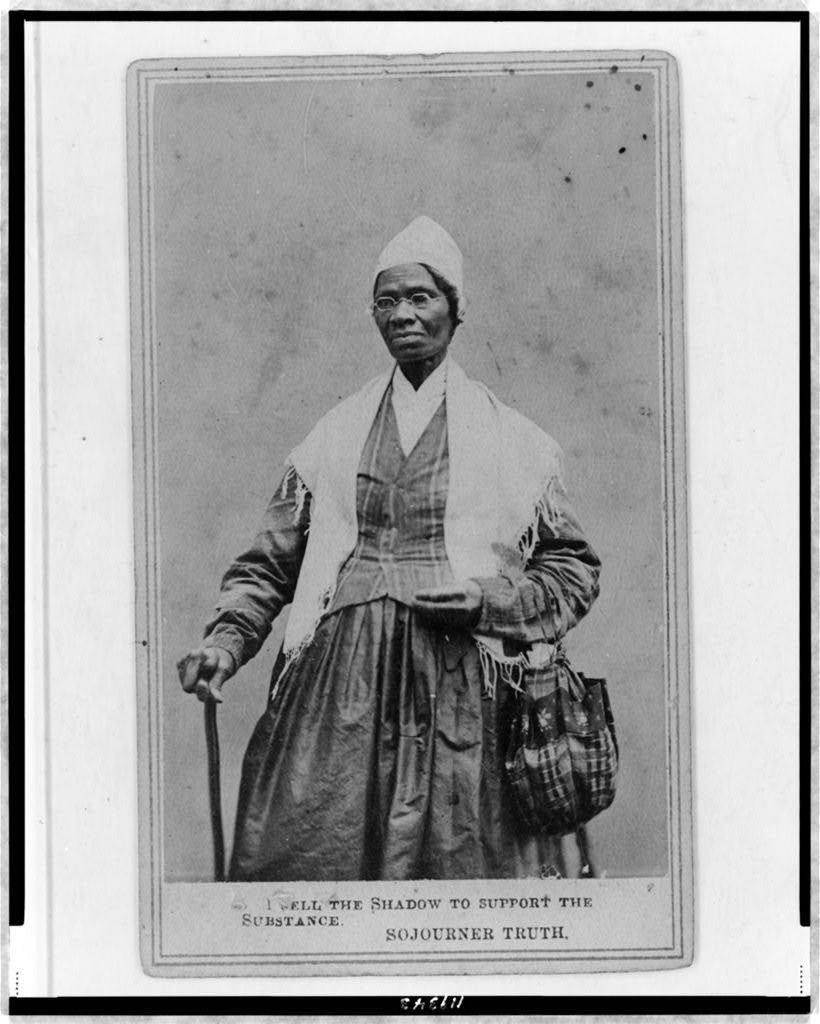 A three-quarter-length portrait of Sojourner Truth standing with spectacles, a shawl, and a peaked cap, resting one hand on a cane.