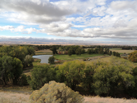 A grassy field marks the former site of the Whitman mission near Walla Walla, Washington, with interpretive markers and the outline of former mission buildings visible in the landscape.